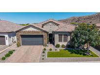 Beautiful single-story home featuring a stone facade, tile roof, desert landscaping, and a gray two-car garage at 9029 S 15Th St, Phoenix, AZ 85042