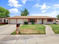 Charming ranch-style home featuring a three-car garage, well-kept lawn, and appealing curb appeal at 1306 W 12Th St, Tempe, AZ 85281
