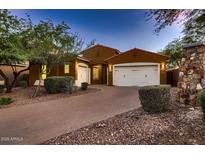 Stunning home featuring a brick driveway, well-manicured landscaping, and a spacious three-car garage at 13145 W Whisper Rock Trl, Peoria, AZ 85383