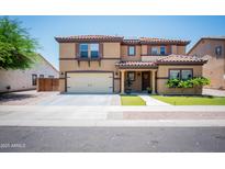 Inviting two-story home featuring a tile roof, manicured lawn, and a welcoming front porch at 13601 W Hearn Rd, Surprise, AZ 85379