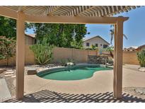 Inviting backyard pool featuring a rock waterfall and mature desert landscaping, perfect for relaxation at 16126 N 159Th Dr, Surprise, AZ 85374