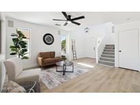 Bright living room with a stylish brown sofa, modern decor, and contemporary ceiling fan at 2112 S 160Th Dr, Goodyear, AZ 85338