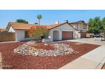 Charming single-story home featuring a well-manicured yard with unique rock landscaping and a two car garage at 3021 E Harmony Cir, Mesa, AZ 85204