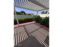 Covered back patio with nice landscaping and a red brick border around the perimeter of the concrete pad at 3510 E Hampton Ave # 133, Mesa, AZ 85204
