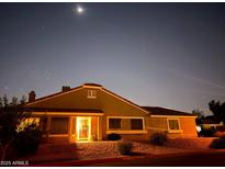 Exterior view of a single story home at dusk with desert landscaping, a welcoming porch light, and clear starry sky at 3510 E Hampton Ave # 133, Mesa, AZ 85204