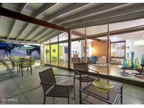 Relaxing covered patio area with ample seating and seamless transition to the home's interior through large glass windows at 421 N Evergreen St, Chandler, AZ 85225
