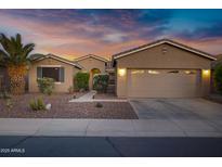 Charming single-story home featuring a two-car garage, desert landscaping, and a beautiful sunset sky at 42711 W Darter Dr, Maricopa, AZ 85138