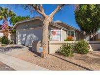 Charming single-Gathering home featuring a two-car garage, complemented by an American flag and mature landscaping at 5210 W Jupiter N Way, Chandler, AZ 85226