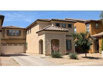 A home with a tile roof, desert landscaping, an arched front door entry, and a two-car garage at 6388 W Ruth Ave, Glendale, AZ 85302