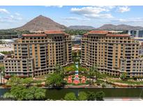 Stunning aerial view of luxury condos with mountain views, lush landscaping, and water features at 7181 E Camelback Rd # 702, Scottsdale, AZ 85251