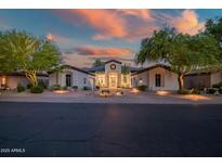 Stunning front exterior view of the home at sunset with landscaped front yard and circular driveway at 7775 E Fledgling Dr, Scottsdale, AZ 85255