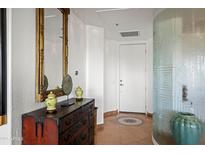 Bright hallway features a decorative mirror and chest, with tiled floor and a patterned glass wall at 17 W Vernon Ave # 508, Phoenix, AZ 85003