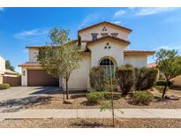 Two-story home with stucco siding, tile roof, arched window, and low-maintenance landscaping at 17153 W Gambit Trl, Surprise, AZ 85387