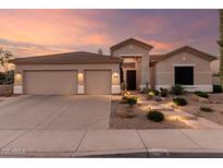 Charming home with a three-car garage and desert landscaping, lit by pathway lighting and a tile roof at 22204 N 55Th St, Phoenix, AZ 85054