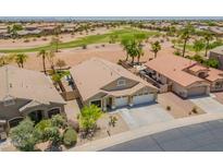 This is an aerial view of a beautiful home with a three car garage, desert landscaping, and a golf course nearby at 22625 N Van Loo Dr, Maricopa, AZ 85138