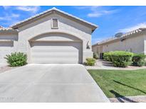 Attached two-car garage with a clean concrete driveway and well-maintained landscaping at 23753 S Vacation Way, Sun Lakes, AZ 85248