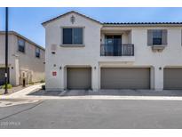 Modern townhome featuring a private balcony, a two-car garage, and neutral stucco exterior at 2941 E Darrow St, Phoenix, AZ 85042