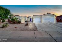 Charming single-story home boasting a three-car garage, desert landscaping, and a welcoming front entrance at 3125 W Desert Ln, Laveen, AZ 85339