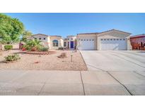 Inviting single-story home featuring a three car garage, desert landscaping, and a beautiful stucco exterior at 3125 W Desert Ln, Laveen, AZ 85339