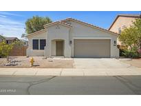 Charming single-story home with a two-car garage and low maintenance desert landscaping at 43690 W Knauss Dr, Maricopa, AZ 85138