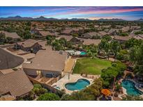 Expansive backyard featuring a sparkling pool and spa, lush landscaping, and mountain views at 6102 E Danbury Rd, Scottsdale, AZ 85254