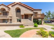 Charming townhome showcasing stucco walls, a terracotta roof, and lush landscaping in a well-maintained community at 700 E Mesquite Cir # O210, Tempe, AZ 85288