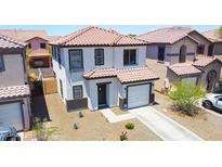 Charming two-story home featuring a tile roof, attached garage, and well-kept landscaping at 7712 S 64Th Ln, Laveen, AZ 85339