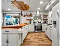 Bright, modern kitchen features custom wood ceiling detail, stainless appliances, and butcher block island at 8116 N 55Th Dr, Glendale, AZ 85302