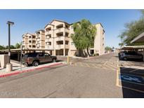 Low angle view of the exterior of a modern-style apartment building with a parking area and desert landscaping at 920 E Devonshire Ave # 2031, Phoenix, AZ 85014