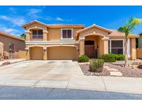 Inviting two-story home showcasing a well-manicured lawn and a spacious three-car garage at 13324 W Annika Dr, Litchfield Park, AZ 85340
