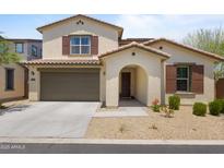 Charming two-story home features a two-car garage and a welcoming arched entryway, beautiful landscaping, and desert charm at 17721 W Cassia Way, Goodyear, AZ 85338