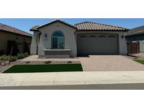 Charming single-story home with a tile roof, manicured lawn, and a brick-paved driveway leading to a two-car garage at 3375 W Verde River Rd, San Tan Valley, AZ 85144