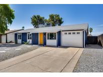 Charming single-story home featuring blue siding, white trim, and a vibrant yellow front door at 3801 E Captain Dreyfus Ave, Phoenix, AZ 85032