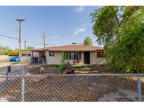 Charming single-story home with desert landscaping and chain link fence at 4501 W Crittenden Ln, Phoenix, AZ 85031