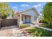Charming bungalow with a gabled roof, brick accents, and a covered porch with light blue doors at 711 E Mckinley St, Phoenix, AZ 85006