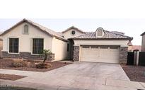 Charming single-story home featuring a two-car garage and decorative stone accents on the facade at 10413 W Roanoke Ave, Avondale, AZ 85392