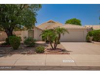 Charming single-story home with desert landscaping, palm trees, and a two-car garage at 10845 W Manzanita Dr, Peoria, AZ 85345