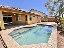 Relaxing backyard oasis featuring a sparkling pool and covered patio, perfect for outdoor entertaining at 16559 W Lincoln St, Goodyear, AZ 85338