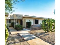 Charming single-story home with desert landscaping, complemented by mature cactus and gravel ground cover at 17441 N Del Webb Blvd, Sun City, AZ 85373