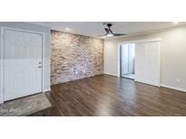 Inviting living room featuring a brick wall, ceiling fan, and wood flooring at 2025 E Campbell Ave # 143, Phoenix, AZ 85016
