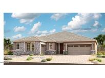 Beautiful single-story home featuring a spacious garage, stone accents, and well-maintained landscaping at 20250 W Monterey Way, Buckeye, AZ 85396