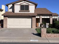 Charming two-story home with a well-maintained lawn, brick accents, and a spacious two-car garage at 23833 N 36Th Dr, Glendale, AZ 85310