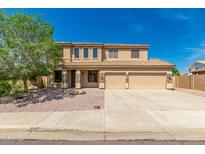 Two-story tan home features a three-car garage, desert landscaping, and a light-colored tile roof at 26272 N 73Rd Dr, Peoria, AZ 85383
