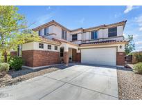 Charming two-story home boasts a brick and stucco exterior with a spacious two car garage and well maintained landscaping at 27053 N 172Nd Ln, Surprise, AZ 85387