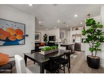 Bright, open-concept living space with modern finishes and stylish decor, seamlessly connecting the kitchen and dining areas at 4548 S Renaissance Dr # 103, Gilbert, AZ 85297