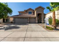Beautiful two-story home boasts a three-car garage and a well-maintained front yard with lush landscaping at 8758 W Hayward Ave, Glendale, AZ 85305