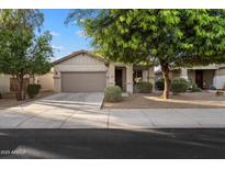 Charming single-story home featuring a neutral color scheme, well-maintained landscaping, and an attached two-car garage at 15844 W Lisbon Ln, Surprise, AZ 85379