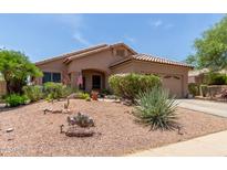 Charming single-story home featuring a well-manicured desert landscape with a cozy front porch at 17201 E Hillcrest Dr, Fountain Hills, AZ 85268