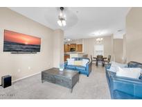 Comfortable living room with modern decor, neutral tones, and large TV mounted on the wall at 2727 N Price Rd # 6, Chandler, AZ 85224
