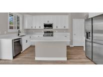 Bright kitchen features white cabinetry, stainless steel appliances, and a center island with quartz countertops at 3376 E Lafayette Ave, Gilbert, AZ 85298